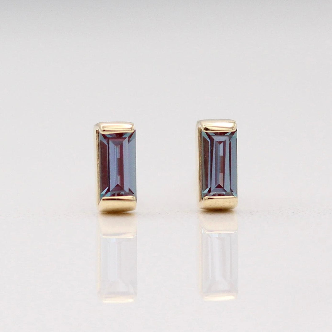 The June Baguette Birthstone Earrings with Alexandrite in Yellow Gold against a white background