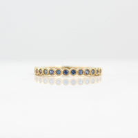 The June Florence Birthstone Wedding Band with Alexandrite in Yellow Gold against a white background