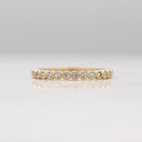 The March Florence Birthstone Wedding Band with Aqua Spinel in Yellow Gold against a white background