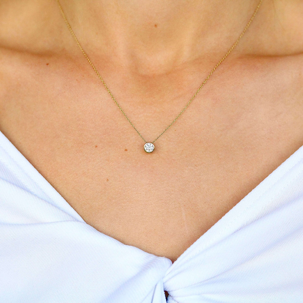 The 1/2ct Diamond Bezel Necklace in yellow gold modeled on a neck