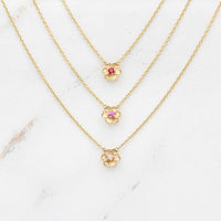The July Birthstone Poppy Necklace with Ruby in Yellow Gold stacked with the January Birthstone Poppy Necklace with Padparadscha Sapphire in Yellow Gold and the October Birthstone Poppy Necklace with Peachy-Pink Sapphire in Yellow Gold against a white background