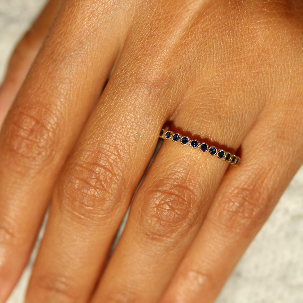The September Florence Birthstone Wedding Band with Blue Sapphire in Yellow Gold modeled