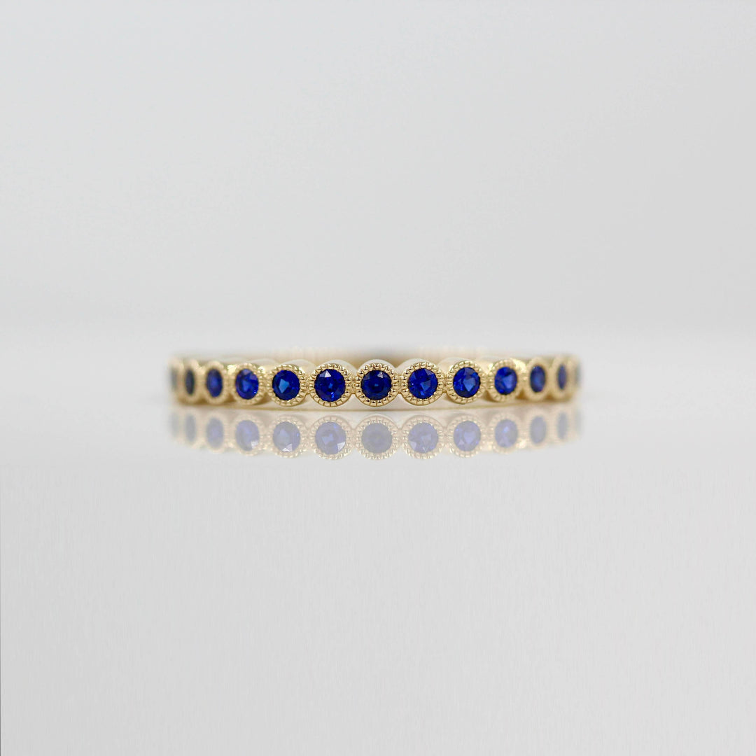 The September Florence Birthstone Wedding Band with Blue Sapphire in Yellow Gold against a white background