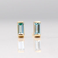 The March Baguette Birthstone Earrings with Aqua Spinel in Yellow Gold against a white background