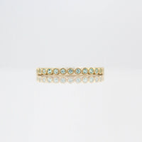 The August Florence Birthstone Wedding Band with Chrysoberyl in Yellow Gold against a white background