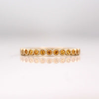 The November Florence Birthstone Wedding Band with Gold Sapphire in Yellow Gold against a white background