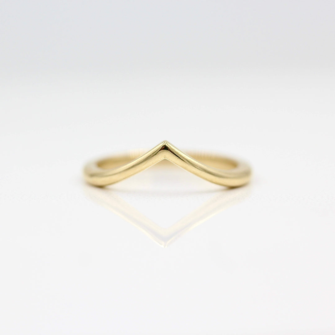 The V Wedding Band in yellow gold against a white background