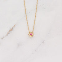 The January Birthstone Poppy Necklace with Padparadscha Sapphire in Yellow Gold against a white background