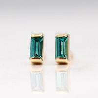 The December Birthstone Baguette Earrings with Paraiba Spinel in Yellow Gold against a white background