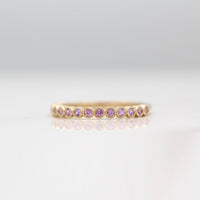 The February Florence Birthstone Wedding Band with Purple Sapphire in Yellow Gold against a white background