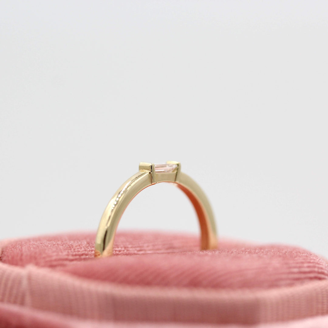 a gold baguette wedding ring in a ring box