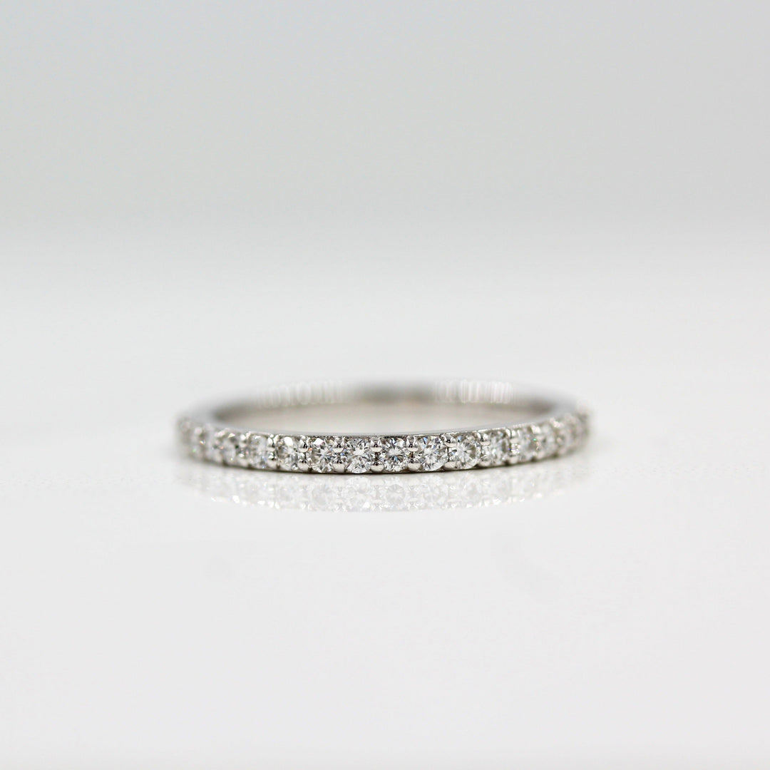 a silver pavé wedding band on white surface