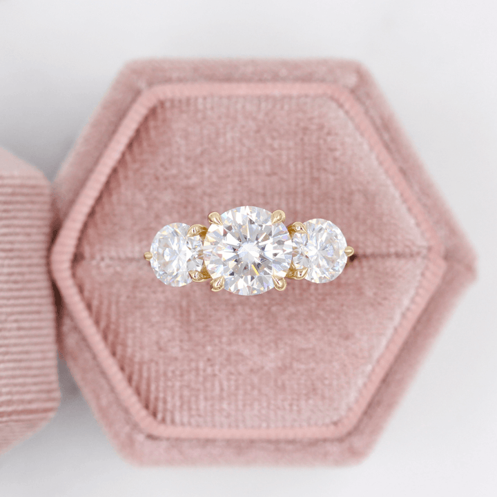 three-stone diamond ring in a pink box