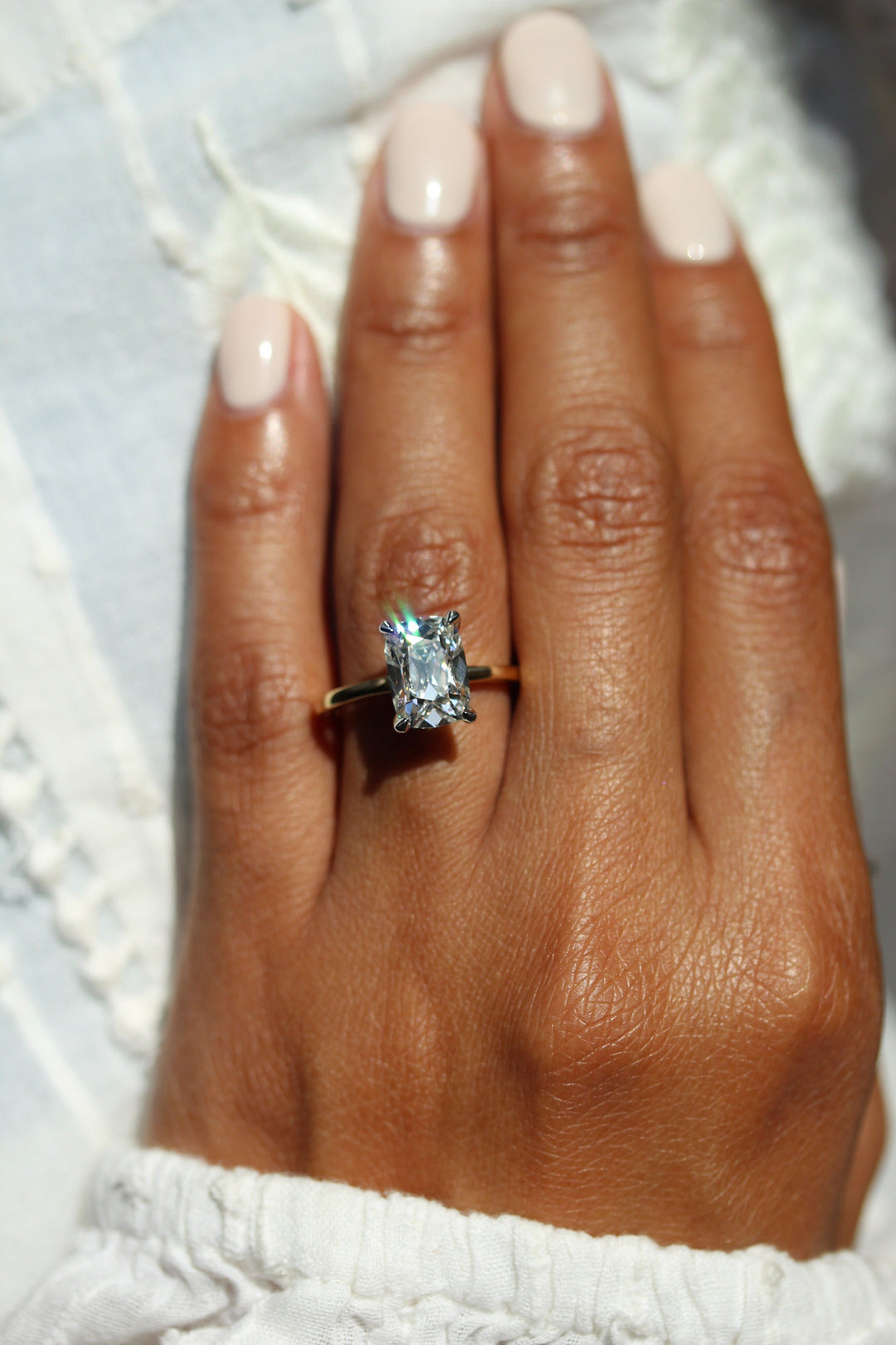 Elongated antique cushion engagement ring on a hand