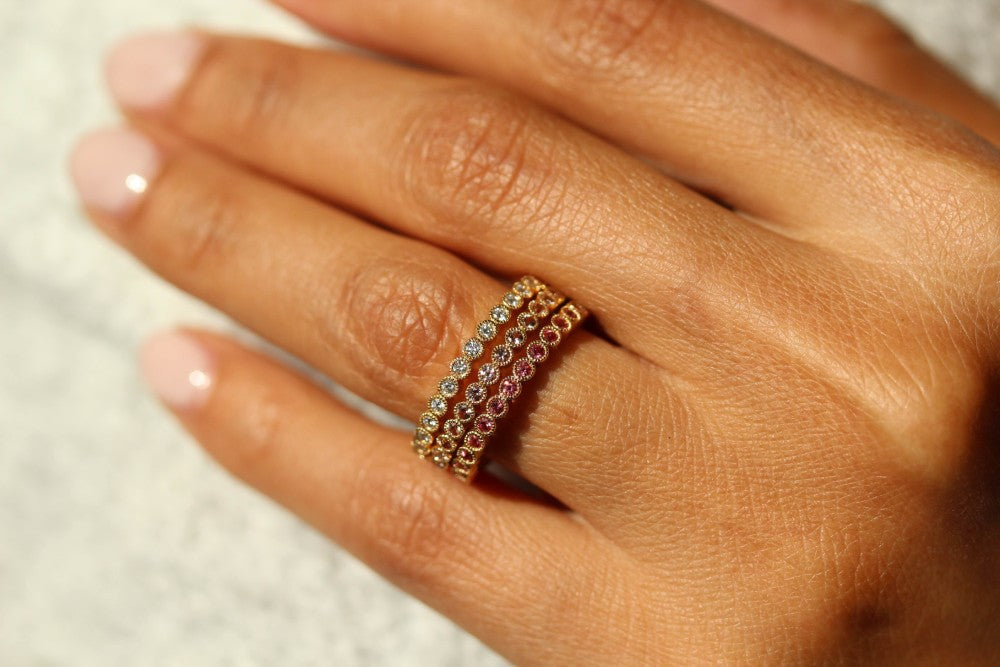 three warm-toned birthstone rings on a hand