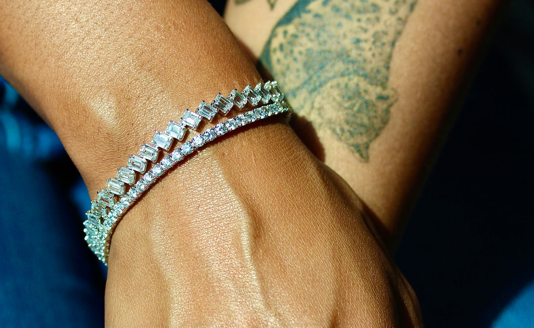 The Emerald and Classic Lab-Grown Diamond Tennis bracelets modeled on an arm with a tiger tattoo