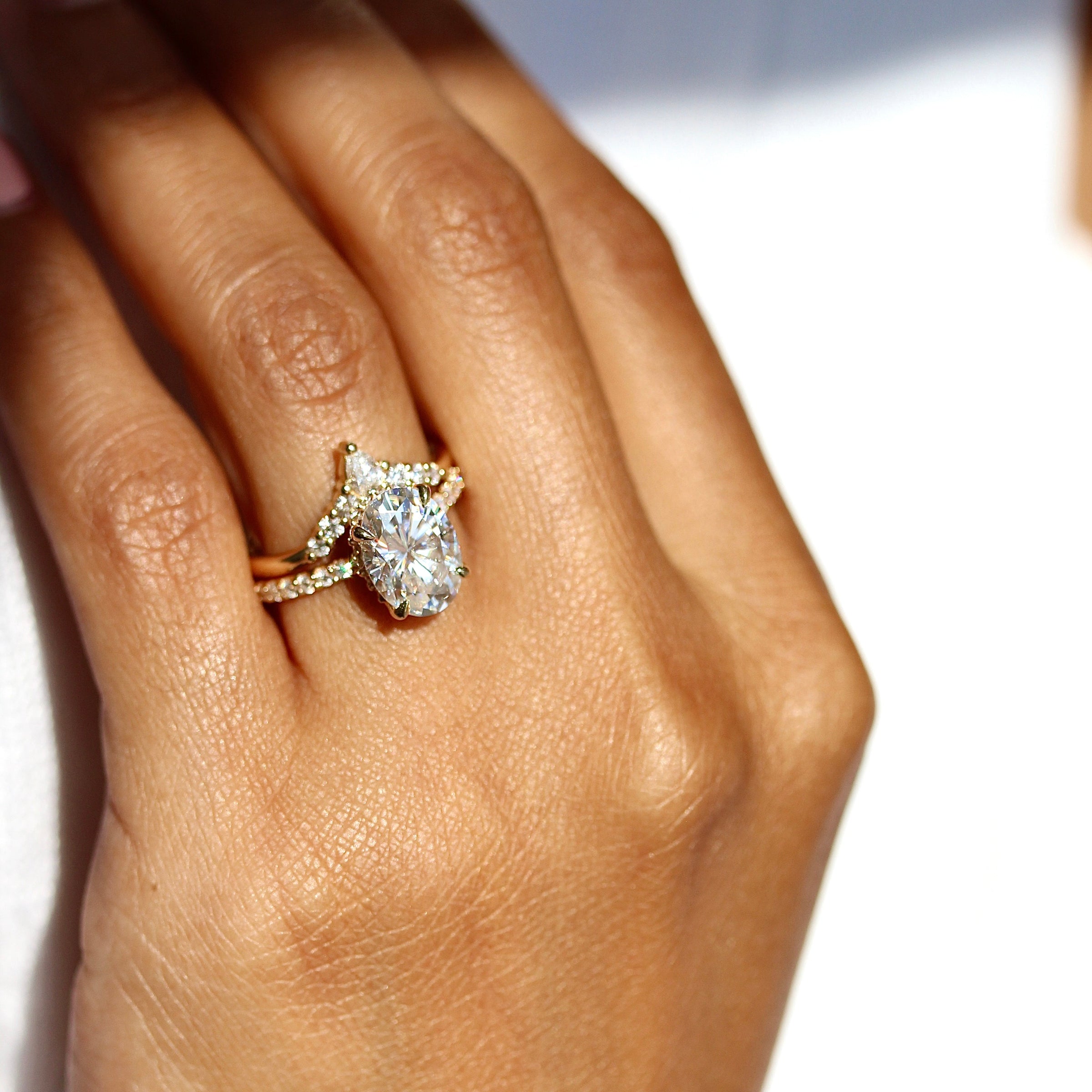 The Grace Ring (Oval) in yellow gold stacked with the Pinnacle wedding band in yellow gold modeled on a hand