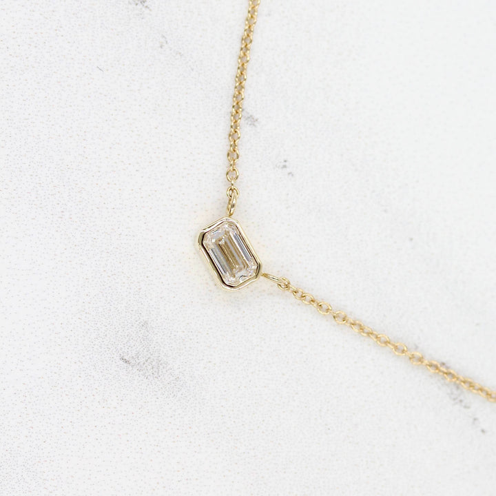 The East-West Emerald Bezel Necklace in Yellow Gold against a white background