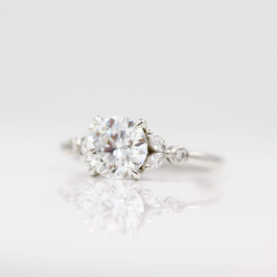 Sophia ring with a round moissanite center in white gold turned slightly against a white background