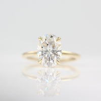 The Celeste Ring in Yellow Gold and Moissanite against a white background