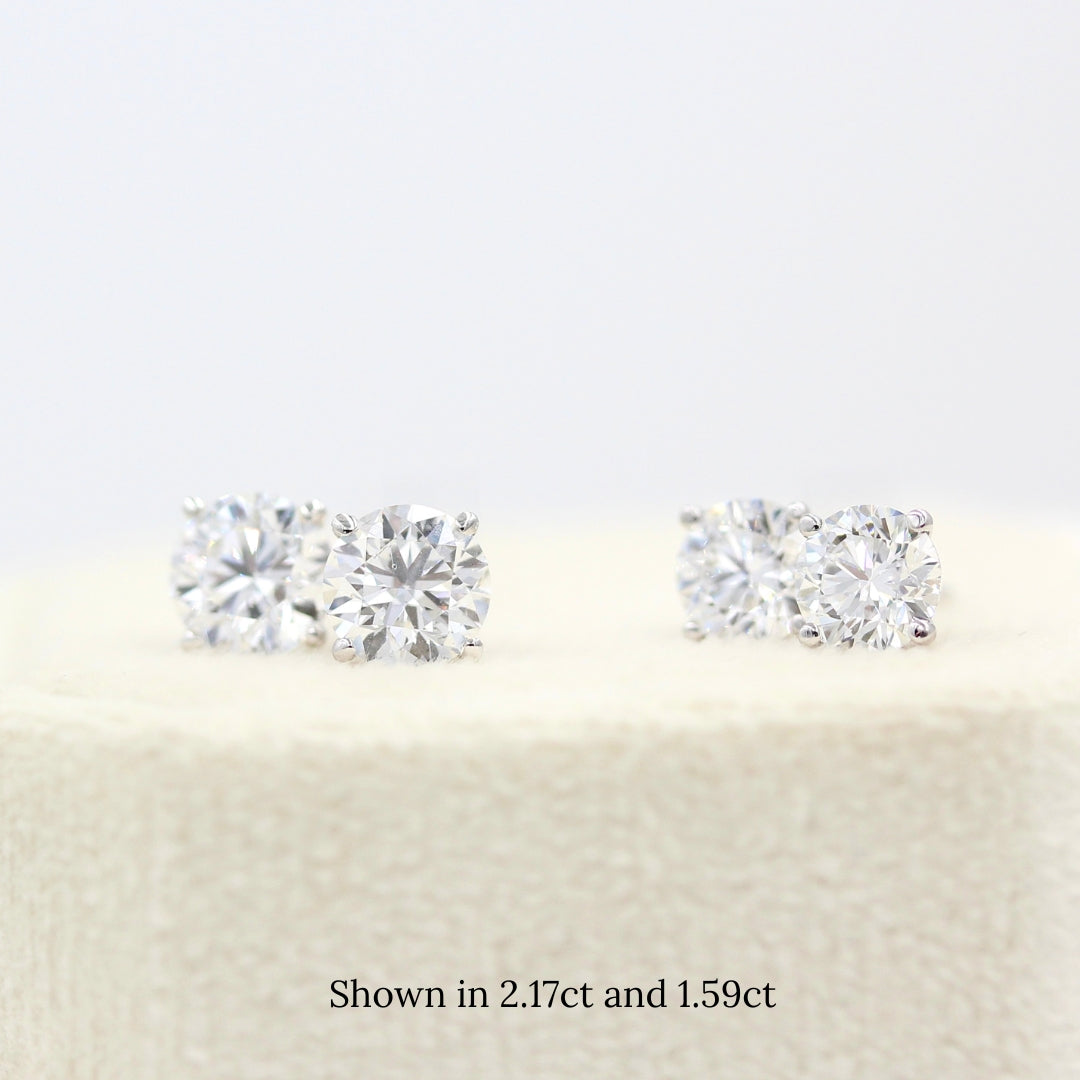 1.59ct and 2.17ct Classic Diamond Studs in white gold atop a white velvet ring box