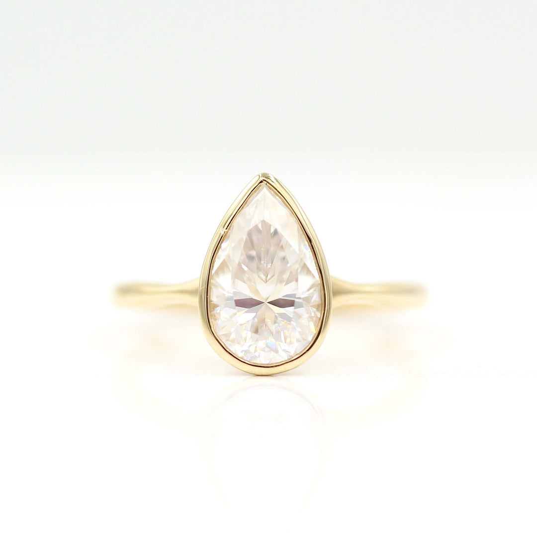 The Stevie Ring (Pear) in yellow gold against a white background
