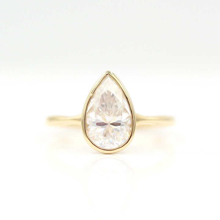 The Stevie Ring (Pear) in yellow gold against a white background