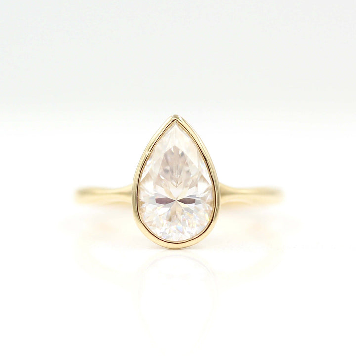 The Stevie Ring (Pear) in yellow gold against a white background