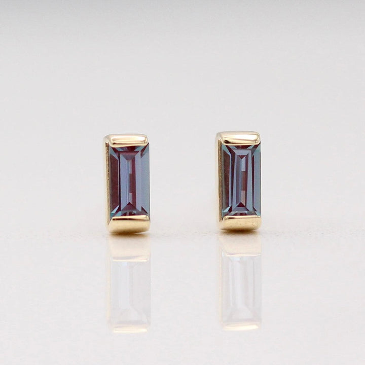 The June Baguette Birthstone Earrings with Alexandrite in Yellow Gold against a white background
