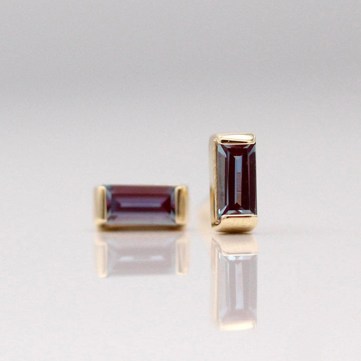 The June Baguette Birthstone Earrings with Alexandrite in Yellow Gold against a white background