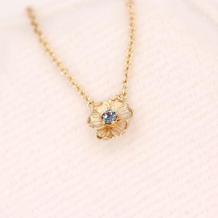The June Birthstone Poppy Necklace with Alexandrite in Yellow Gold atop of a white velvet ring box