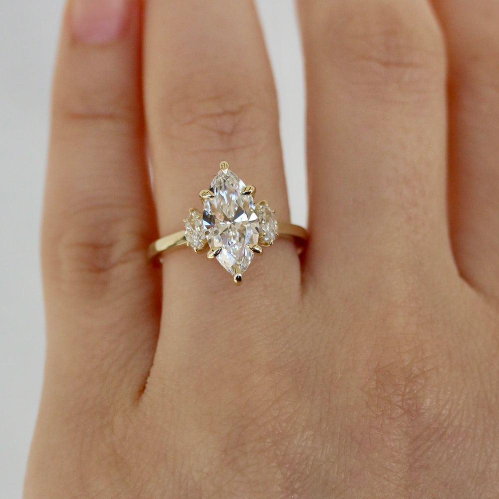 Marquise Diamond Engagement ring with Marquise side stones on a hand. 