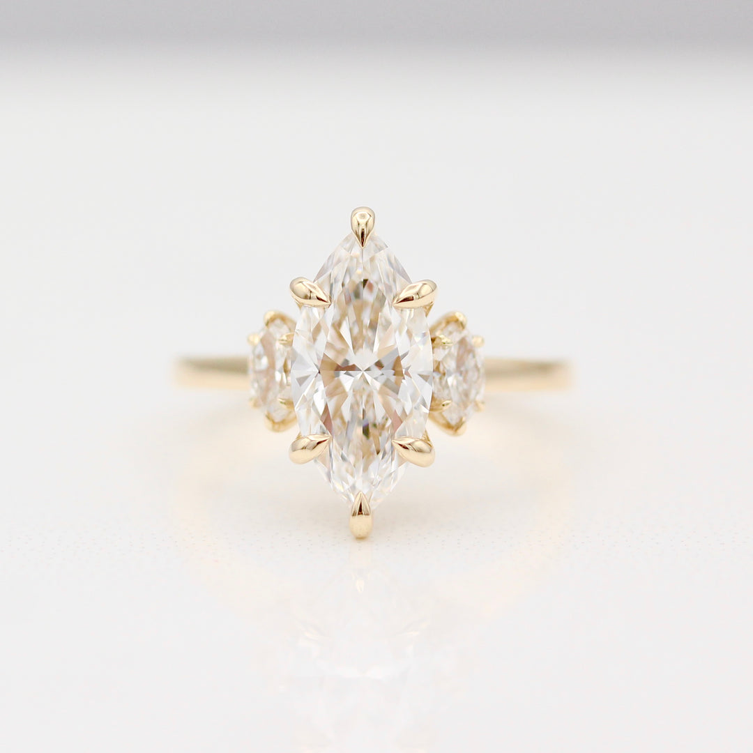 Yellow Gold Engagement Ring with a Marquise Diamond Center stone and Marquise Diamond side stones.