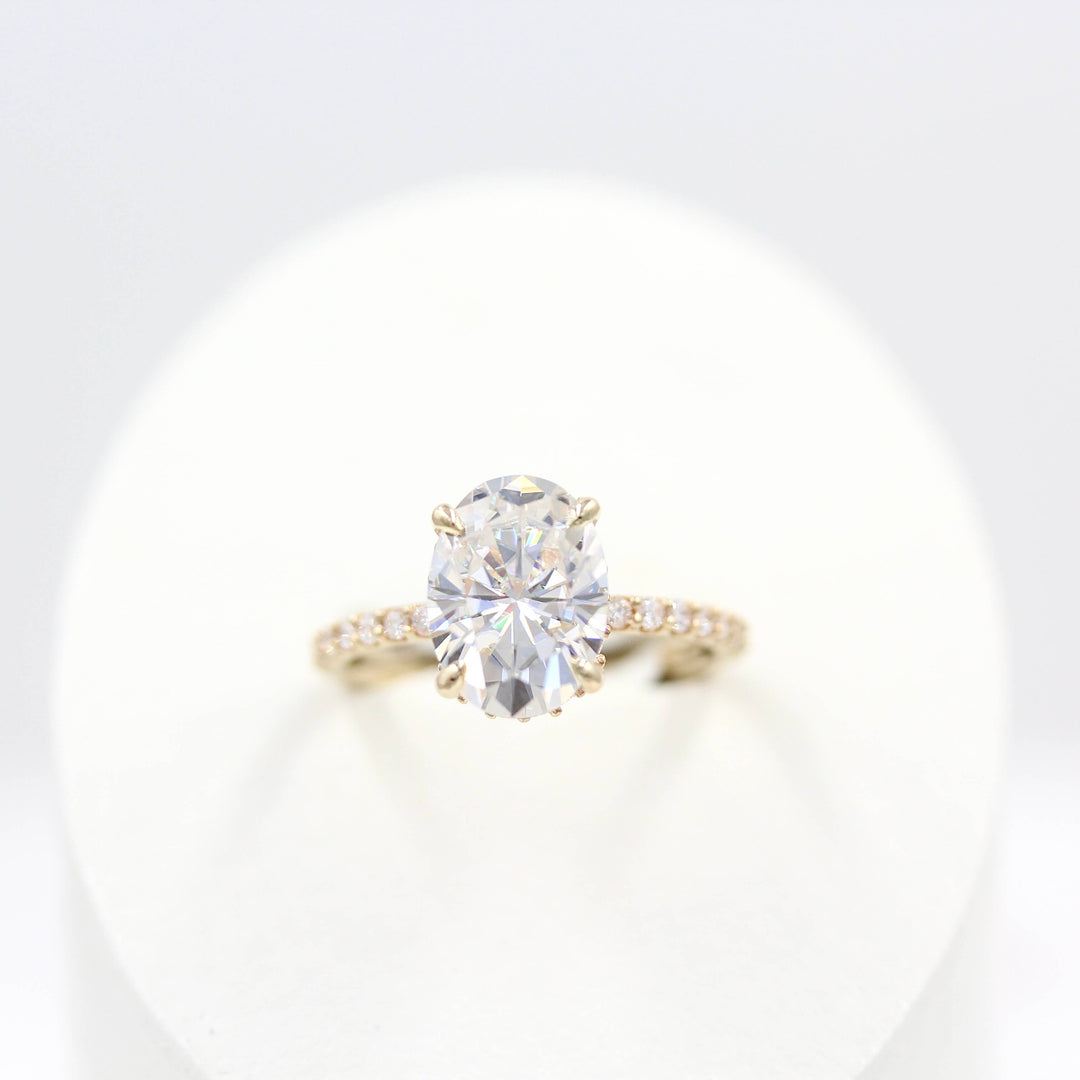 The Athena Hidden Halo Ring (Oval) in Yellow Gold in a white velvet ring box