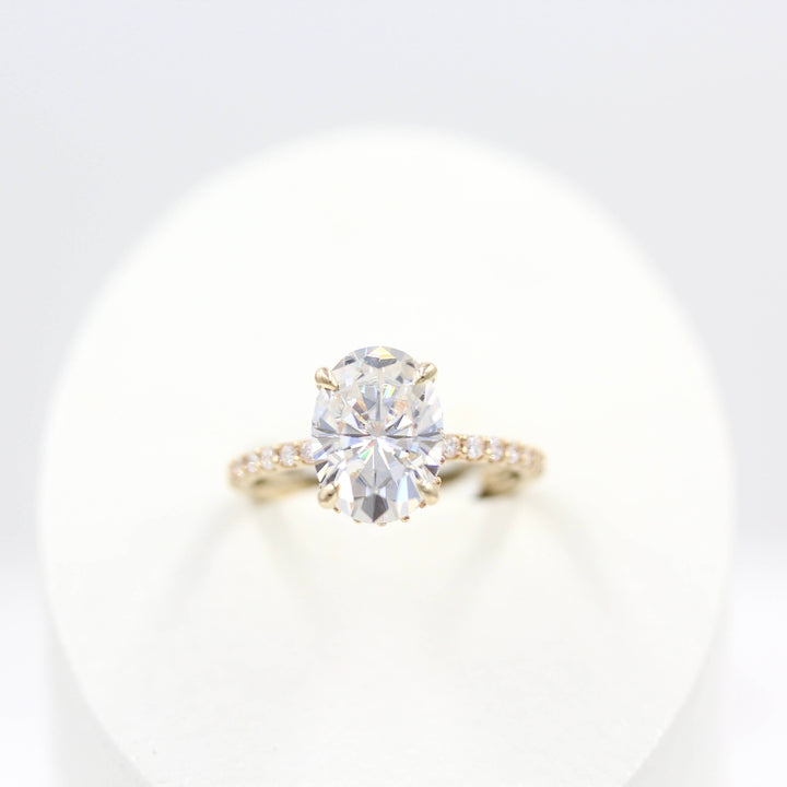 The Athena Hidden Halo Ring (Oval) in Yellow Gold in a white velvet ring box