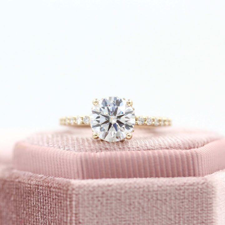 yellow gold Athena ring round diamond with moissanite accents on pink velvet platform