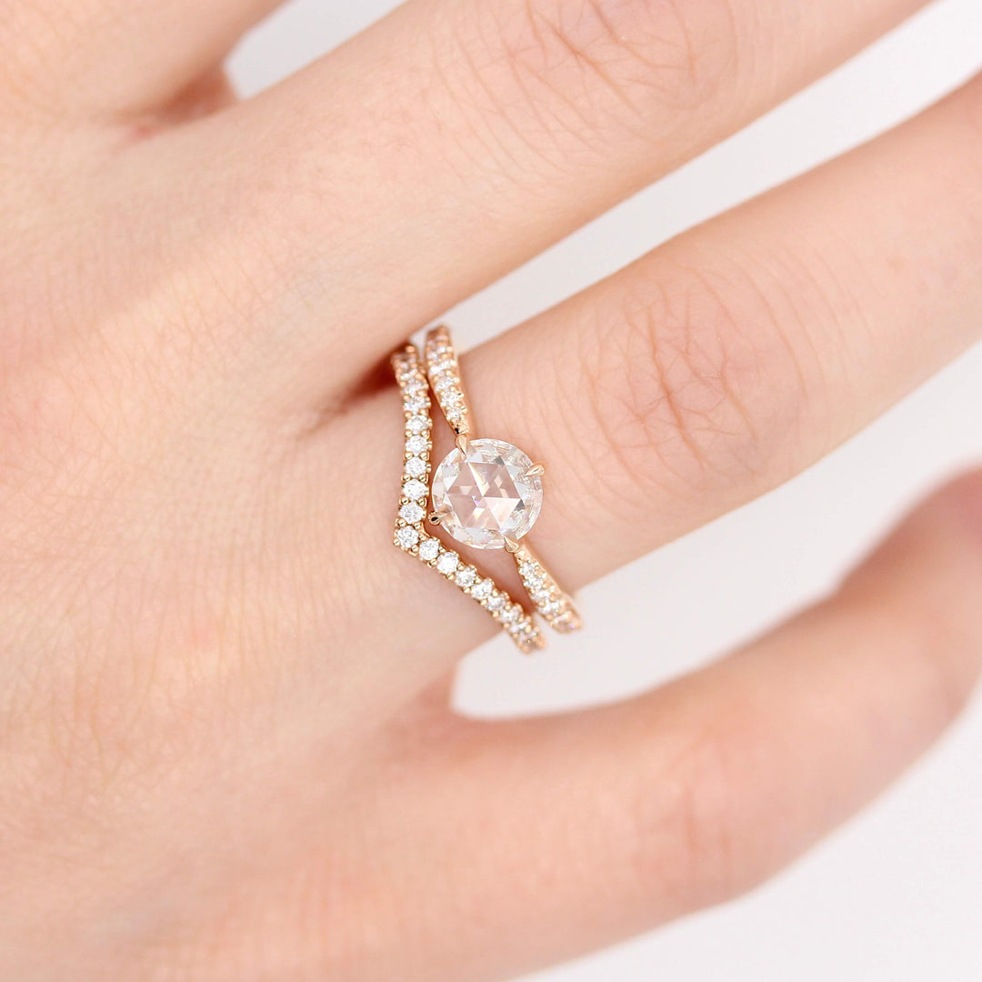 The Aurora Ring (Round) in rose gold stacked with the Diamond V Band in rose gold modeled on a hand