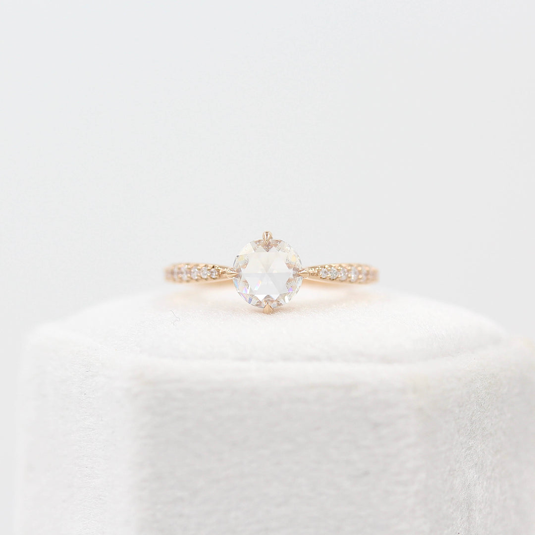 The Aurora Ring (Round) in Rose Gold and 1ct Moissanite atop a white velvet ring box