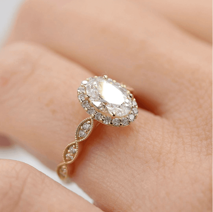 A yellow gold oval ring on a finger