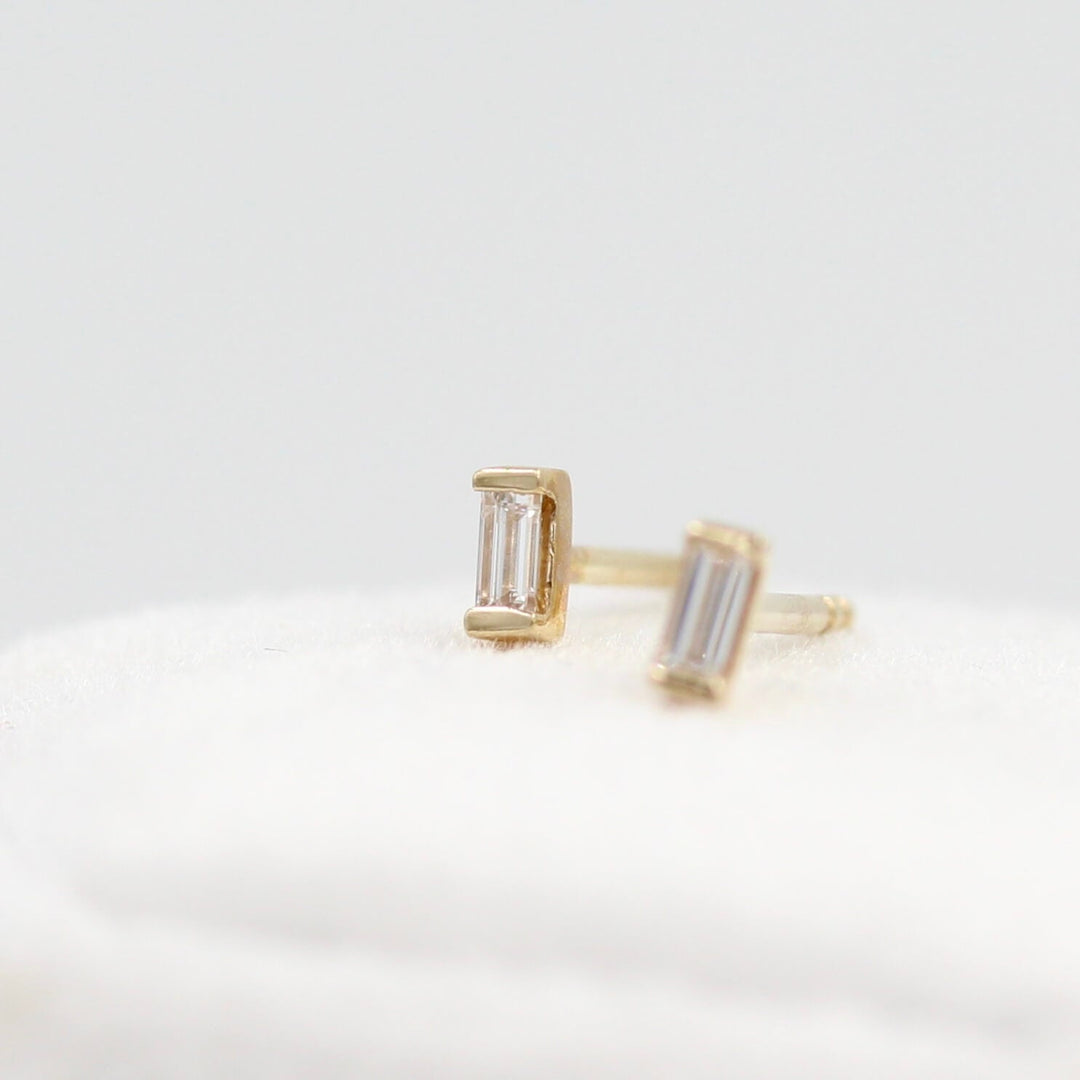 Baguette Earrings in Yellow Gold atop a white velvet ring box