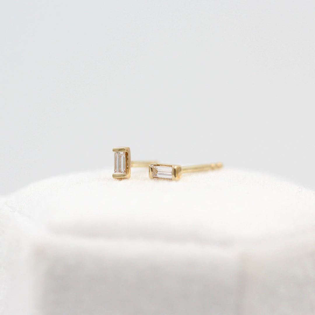 Baguette Earrings in Yellow Gold atop a white velvet ring box