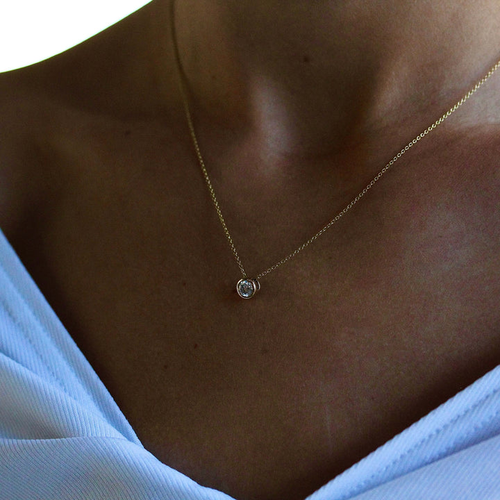 The 1/2ct Diamond Bezel Necklace in yellow gold modeled on a neck