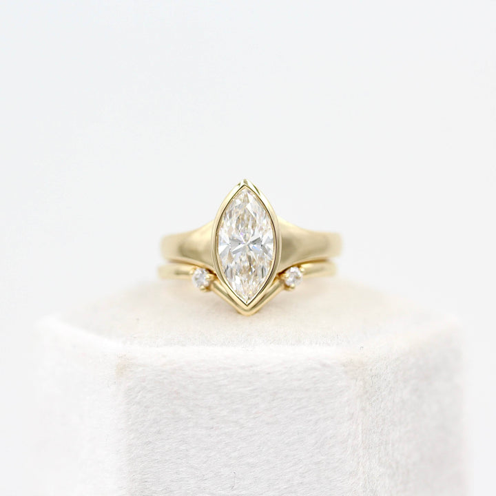 The Billie Ring (Marquise) in yellow gold stacked with the Double Diamond V Band in yellow gold on a white velvet ring box