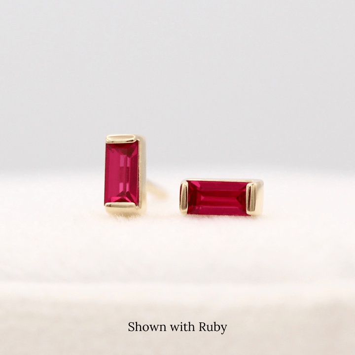 The July Baguette Birthstone Earrings with Ruby in Yellow Gold atop of a white velvet ring box