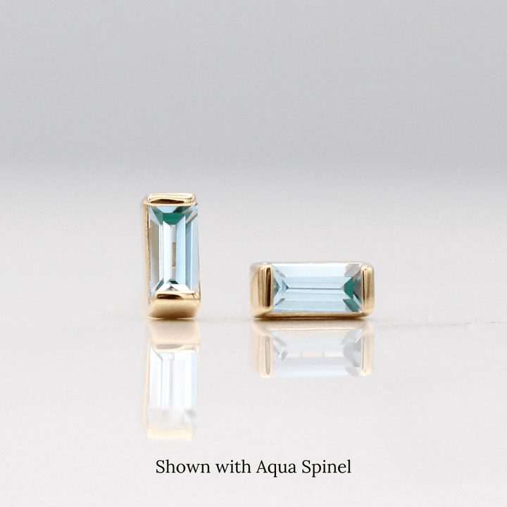 The August Baguette Birthstone Earrings with Aqua Spinel in Yellow Gold against a white background