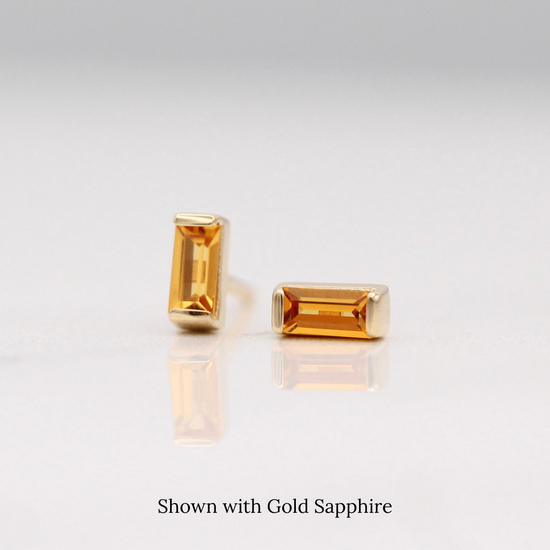 The November Baguette Birthstone Earrings with Gold Sapphire in Yellow Gold against a white background