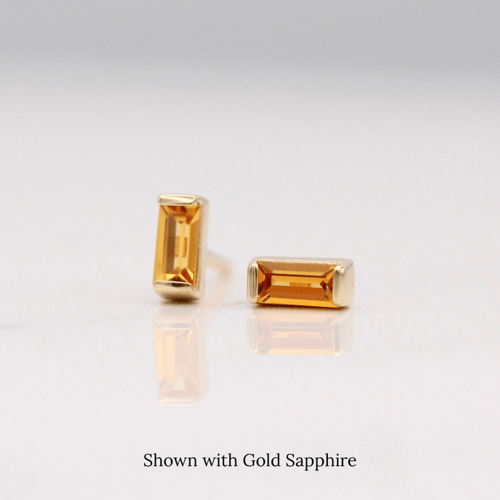 The November Baguette Birthstone Earrings with Gold Sapphire in Yellow Gold against a white background