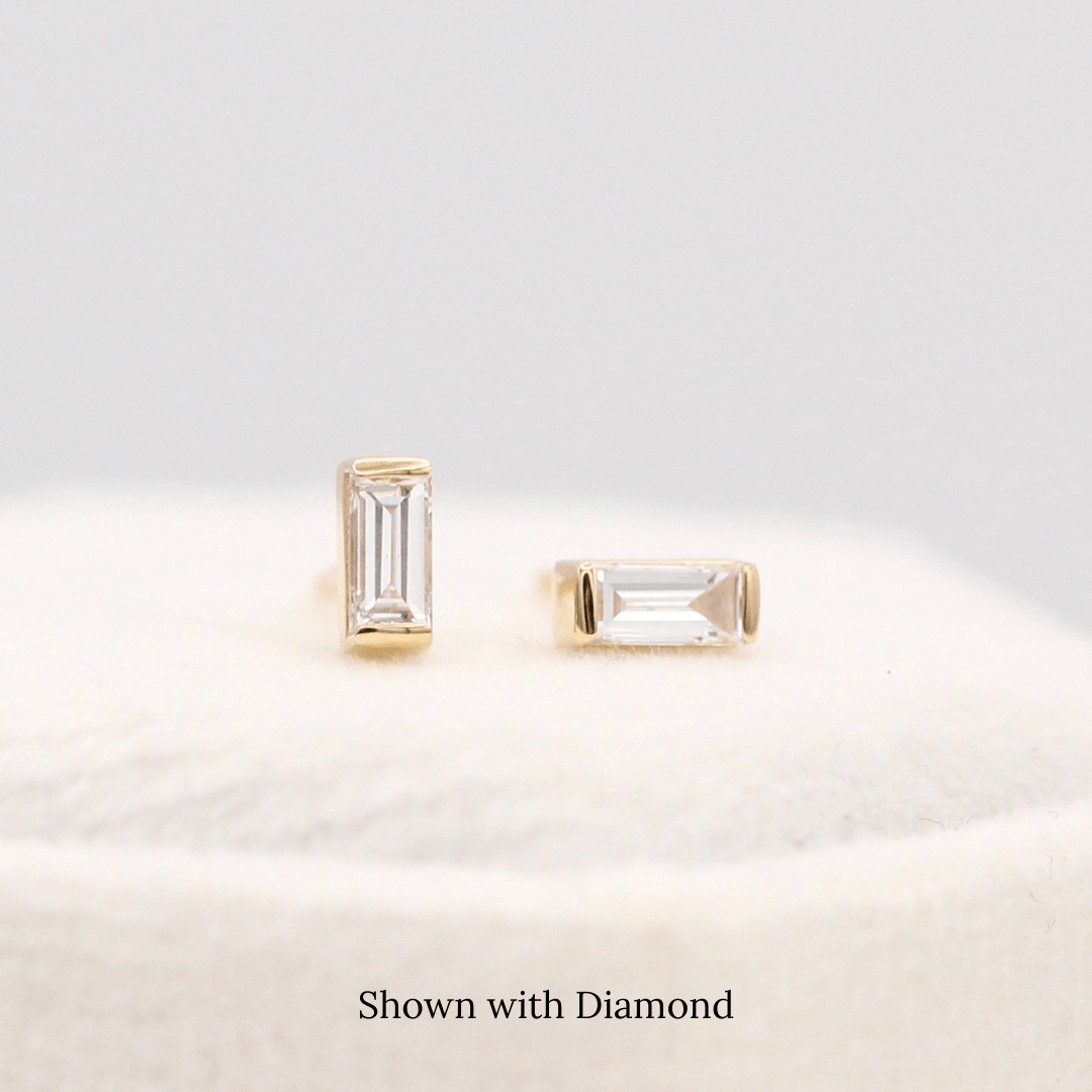 The April Baguette Birthstone Earrings with Lab-Grown Diamond in Yellow Gold atop of a white velvet ring box