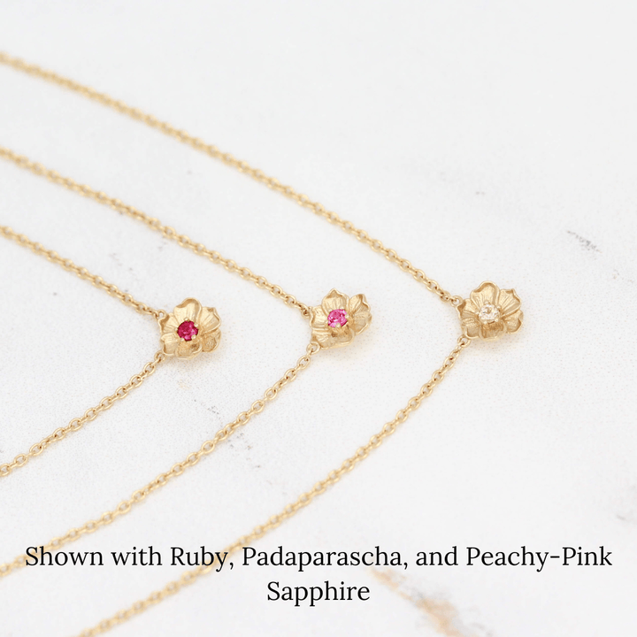 The July Birthstone Poppy Necklace with Ruby in Yellow Gold stacked with the January Birthstone Poppy Necklace with Padaparascha Sapphire in Yellow Gold and the October Birthstone Poppy Necklace with Peachy-Pink Sapphire in Yellow Gold against a white background
