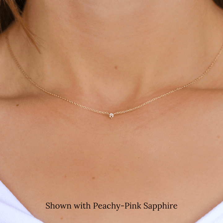 The October Tiny Trillion Birthstone Necklace with Peachy-Pink Sapphire in Yellow Gold modeled
